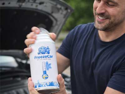 Person som skakar en FreezeCar AC-burk kraftigt